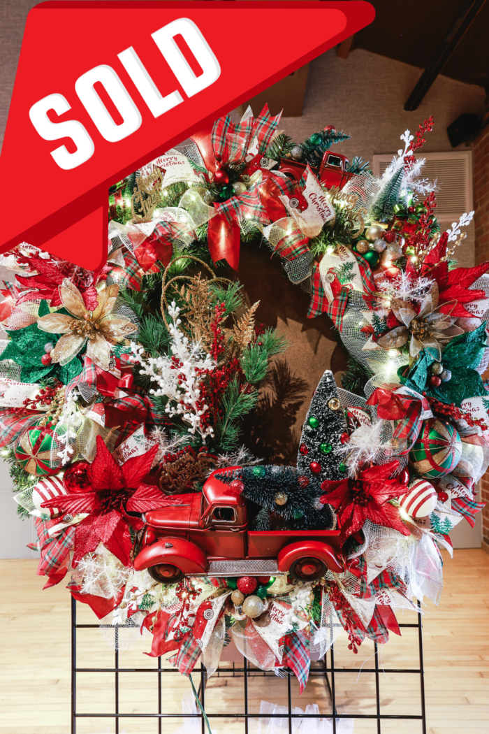 A little red truck haulin' a Christmas Wreath